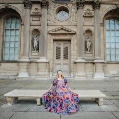 Rachel Murphy seated at a European palace in a floral dress