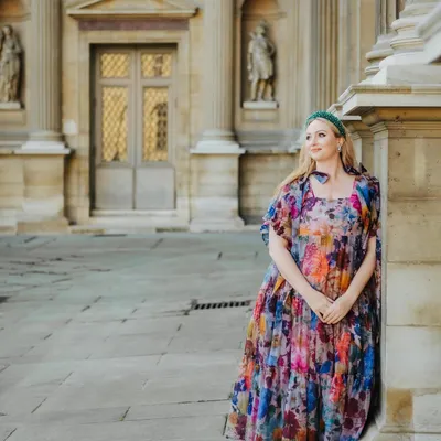 Rachel Murphy leaning against a palace column in a floral dress